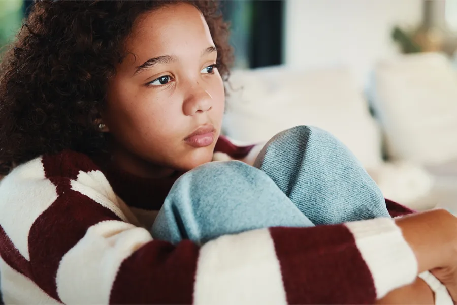 Unhappy, child thinking on sofa
